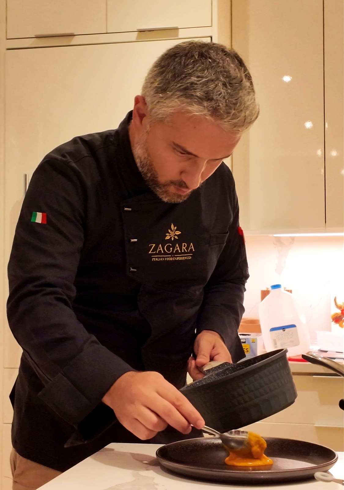 Chef Emanuele Pinzino plating a course in a private home kitchen